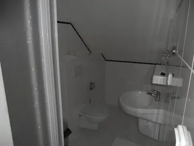a white bathroom with a toilet and a sink at Penzion Oáza in Štětí