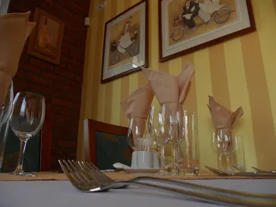 a table with wine glasses and napkins on it at Penzion Oáza in Štětí