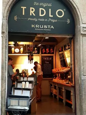 a man standing at a counter in a bakery at No1 Style & Design XXL City Centre Apartment in Prague