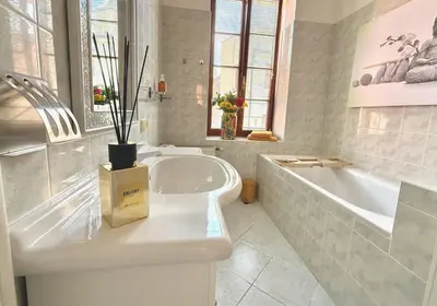 a bathroom with a large tub and a white tub and a sink at No1 Style & Design XXL City Centre Apartment in Prague