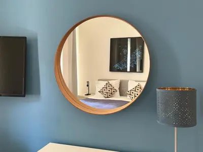 a circular mirror on a blue wall with a couch at No1 Style & Design XXL City Centre Apartment in Prague