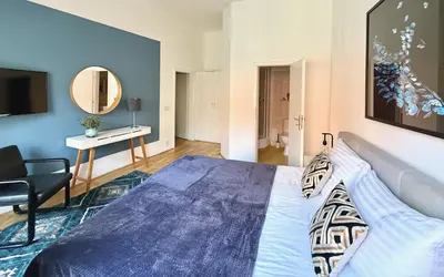 a bedroom with a bed and a table and a mirror at No1 Style & Design XXL City Centre Apartment in Prague