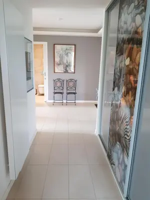 a hallway with white tile flooring and art on the walls at Praha Karibik in Prague