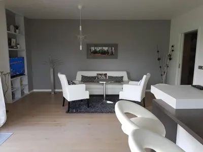 a living room with white furniture and a table and chairs at Praha Karibik in Prague