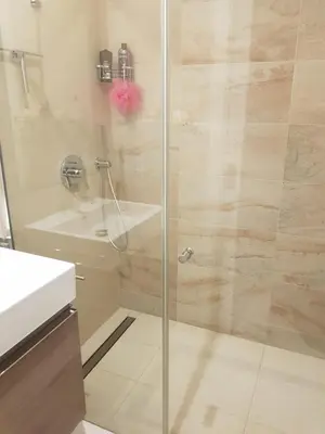 a bathroom with a glass shower with a sink at Praha Karibik in Prague