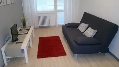 a living room with a couch and a desk with a television at Hotel Terek in Štětí