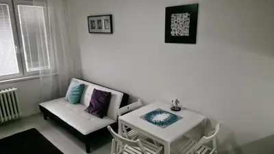 a living room with a white couch and a table at Hotel Terek in Štětí