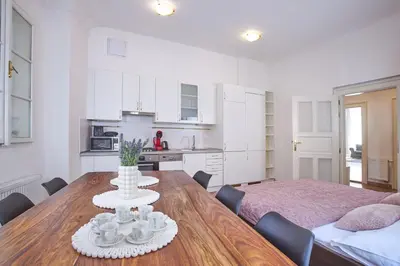 a kitchen and dining room with a table and chairs at Charles Bridge Suites in Prague