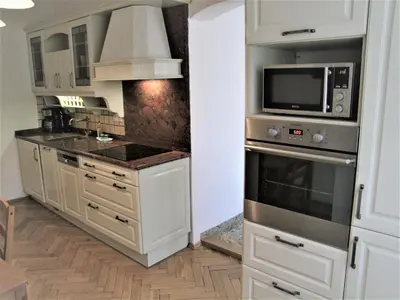 a kitchen with white cabinets and a microwave at Charles Bridge Suites in Prague