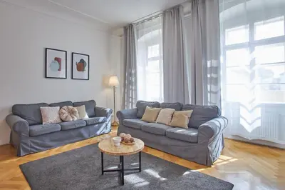 a living room with two couches and a table at Charles Bridge Suites in Prague