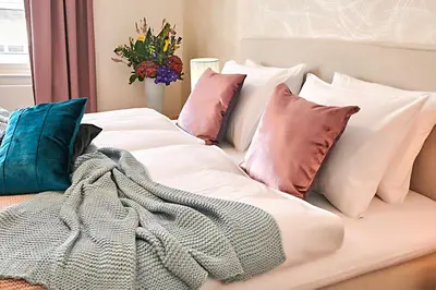 a bed with pillows and a blanket on it at Palace Dlouhá Apartments - Old Town in Prague