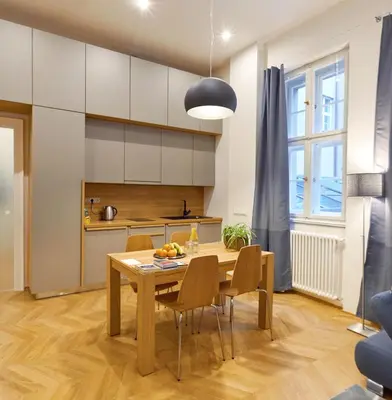 a kitchen and dining room with a wooden table and chairs at Palace Dlouhá Apartments - Old Town in Prague