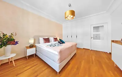 a bedroom with a large bed and a table at Palace Dlouhá Apartments - Old Town in Prague