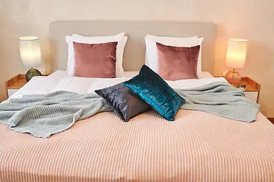 a bed with two pillows and a blanket on it at Palace Dlouhá Apartments - Old Town in Prague