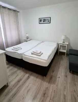 a bedroom with a bed with white sheets and wooden floors at Hotel Union in Louny