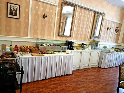 a kitchen with white tables with food on them at Hotel Union in Louny