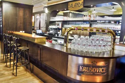 a bar in a restaurant with glasses on the counter at Hotel Union in Louny