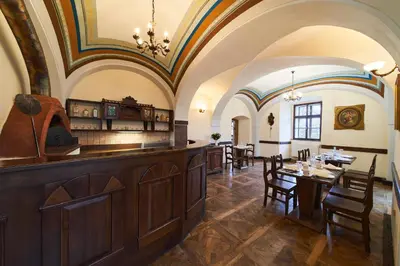 a kitchen and dining room with a table and chairs at Penzion Zámek Lešany in Netvořice