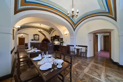 a dining room with tables and chairs and a ceiling at Penzion Zámek Lešany in Netvořice