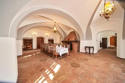 a large dining room with a table and a chandelier at Penzion Zámek Lešany in Netvořice