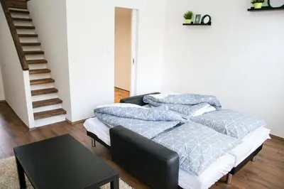 a living room with two beds and a table at Sunny Aircon Apartment in the Centre of Slaný in Slaný