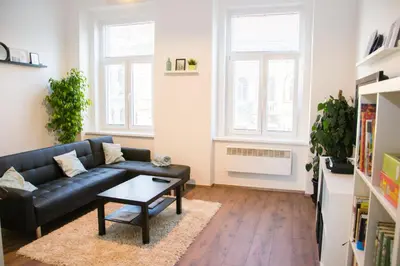 a living room with a black couch and a table at Sunny Aircon Apartment in the Centre of Slaný in Slaný