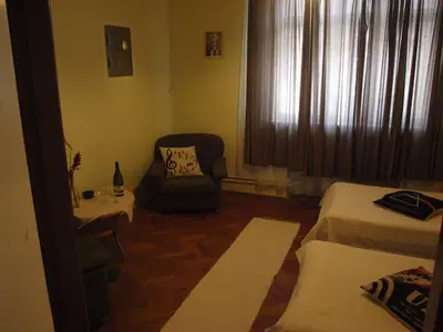 a room with two beds and a chair and a window at Apartmány Rossa in Louny