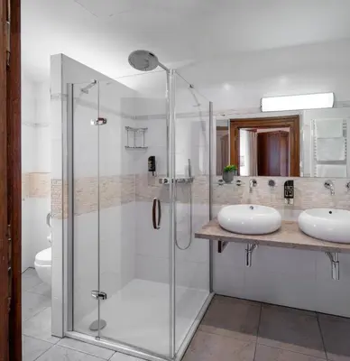a bathroom with two sinks and a glass shower at Aurus by Adrez in Prague