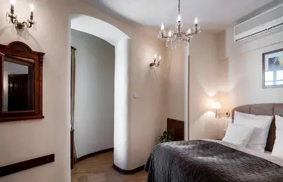 a bedroom with a bed and a chandelier at Aurus by Adrez in Prague