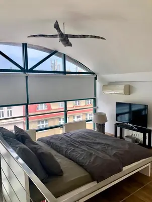 a bedroom with a bed and a large window at Romantic studio with jacuzzi in Prague