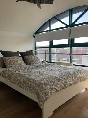 a bed in a room with a large window at Romantic studio with jacuzzi in Prague