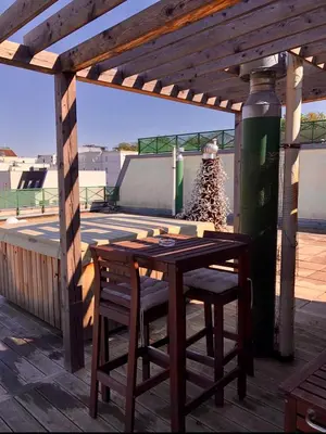 a wooden table and chairs on a patio at Romantic studio with jacuzzi in Prague