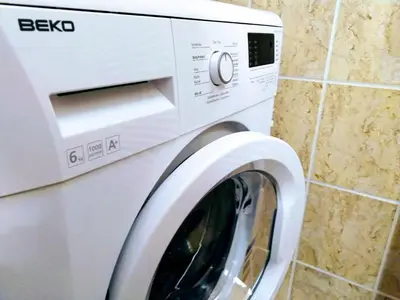a white washing machine sitting next to a wall at Apartment Archa Poděbrady in Poděbrady