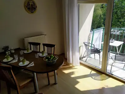 a dining room with a table and chairs and a balcony at Apartment Archa Poděbrady in Poděbrady