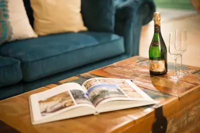 a bottle of wine and a book on a table with a wine glass at Gigantic Boho Chic 3 Bedroom 3 Bathroom Loft with Hanging Chair in Prague