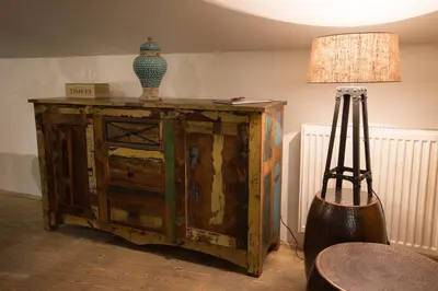 an old wooden cabinet with a lamp on top of it at Gigantic Boho Chic 3 Bedroom 3 Bathroom Loft with Hanging Chair in Prague