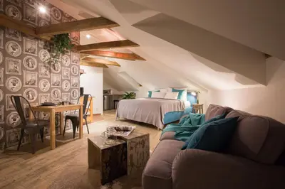 a living room with a couch and a bed and a table at Gigantic Boho Chic 3 Bedroom 3 Bathroom Loft with Hanging Chair in Prague