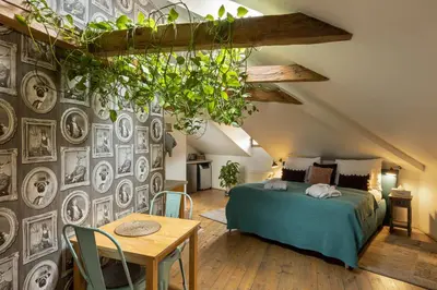 a bedroom with a bed and a wall with pictures at Gigantic Boho Chic 3 Bedroom 3 Bathroom Loft with Hanging Chair in Prague
