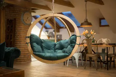 a hanging chair in a living room with a table at Gigantic Boho Chic 3 Bedroom 3 Bathroom Loft with Hanging Chair in Prague