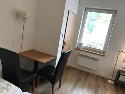 a small room with a table and chairs and a window at Penzion Nová Hospoda in Prague
