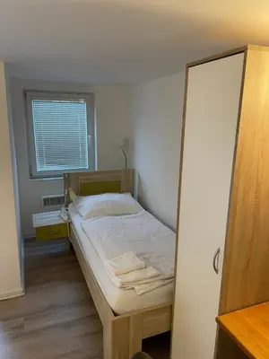 a small bedroom with a bed and a window at Penzion Nová Hospoda in Prague