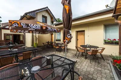 a patio with tables and chairs and an umbrella at Penzion Nová Hospoda in Prague
