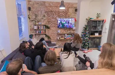 a group of people sitting on a couch in a living room at The RoadHouse Prague in Prague