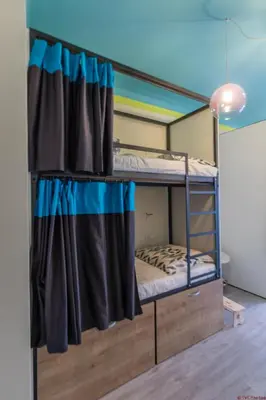 two bunk beds in a room with a curtain at The RoadHouse Prague in Prague