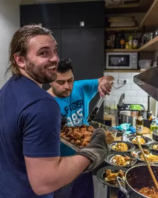two men preparing food in a kitchen at The RoadHouse Prague in Prague