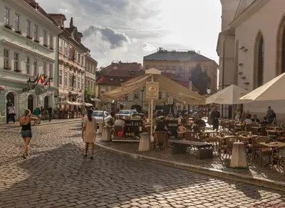 a group of people walking down a street in a city at The RoadHouse Prague in Prague