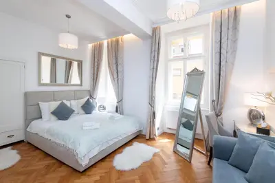 a bedroom with a bed and a mirror and a chair at Arch II at Wenceslas in Prague