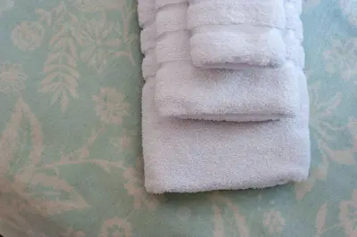 a white towel laying on top of a bed at Arch II at Wenceslas in Prague