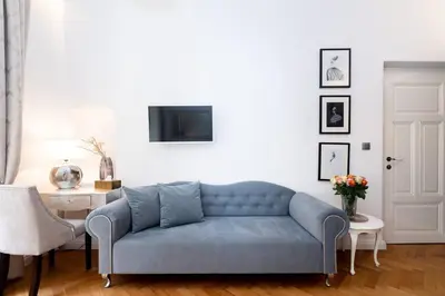a living room with a blue couch and a tv at Arch II at Wenceslas in Prague