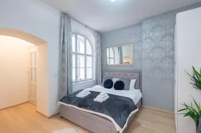 a bedroom with a large bed with blue wallpaper at Quiet apartment in the heart of Old Town centre in Prague